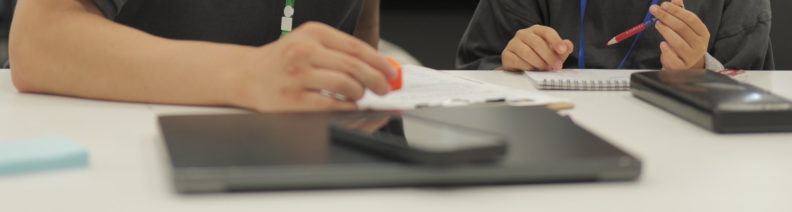 学生と子どもが教材を囲み、一緒に手を動かして学ぶ手元